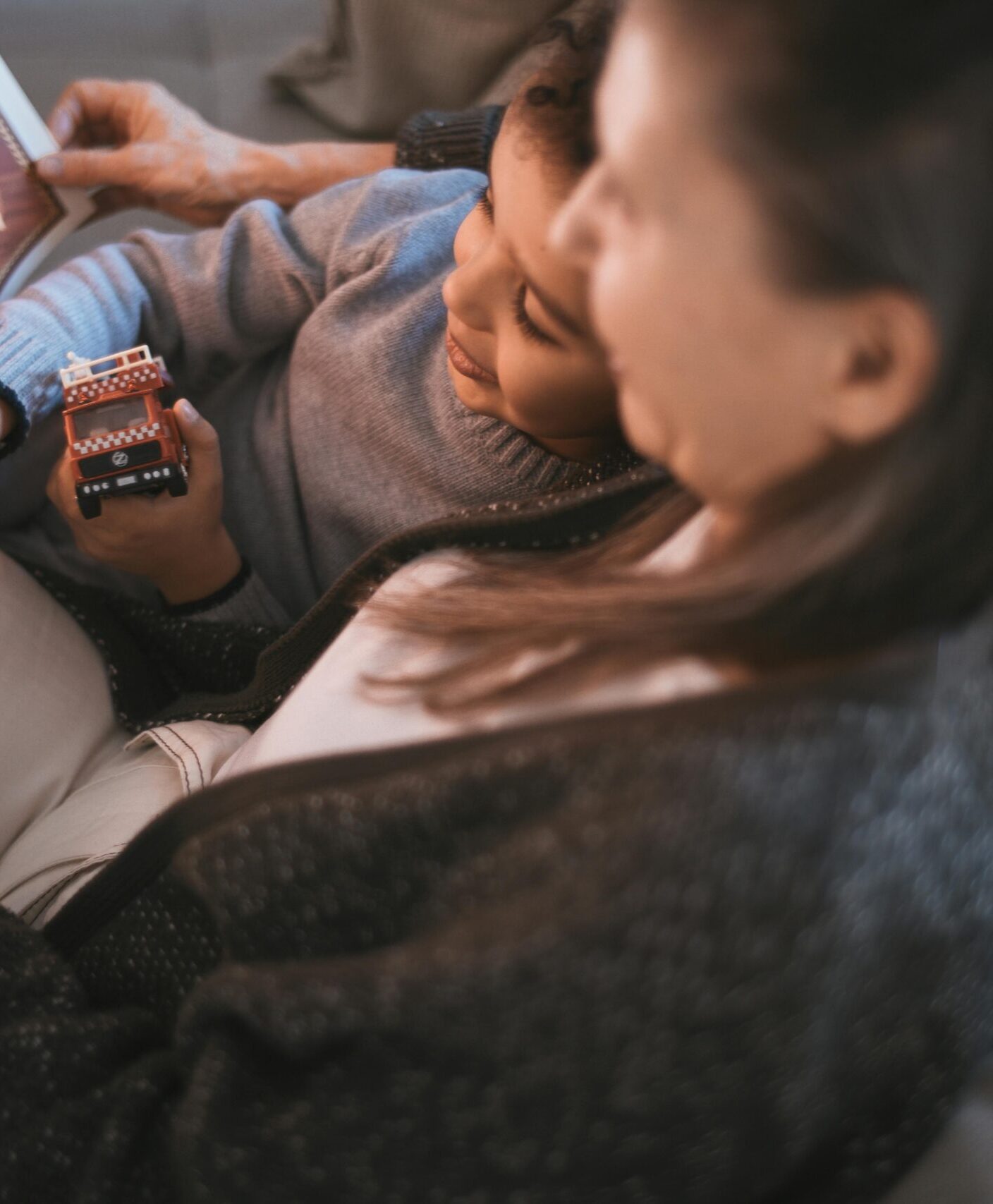 Grandmother and child enjoying a cozy afternoon reading together indoors.